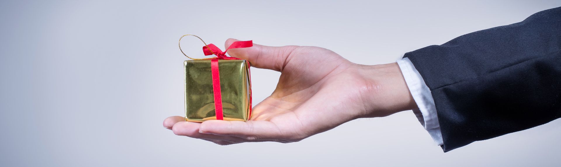 Hand holding a gift to represent benefits